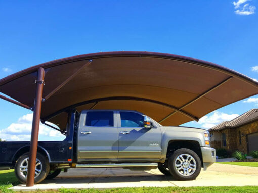 Curved residential carport shade structure over a pickup truck