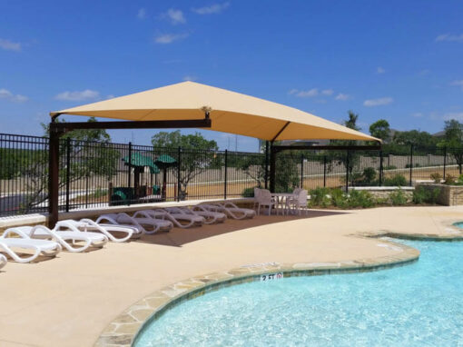 Umbrella-style shade structures over an HOA community pool deck