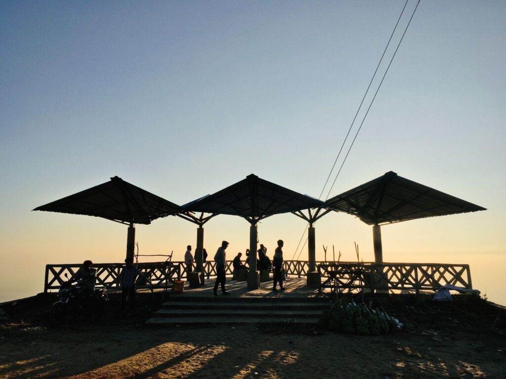 A scenic, elevated pavilion with metal-roof shade structures, offering a relaxing, open-air retreat at sunset. This permanent outdoor shade system provides protection while allowing visitors to enjoy nature.