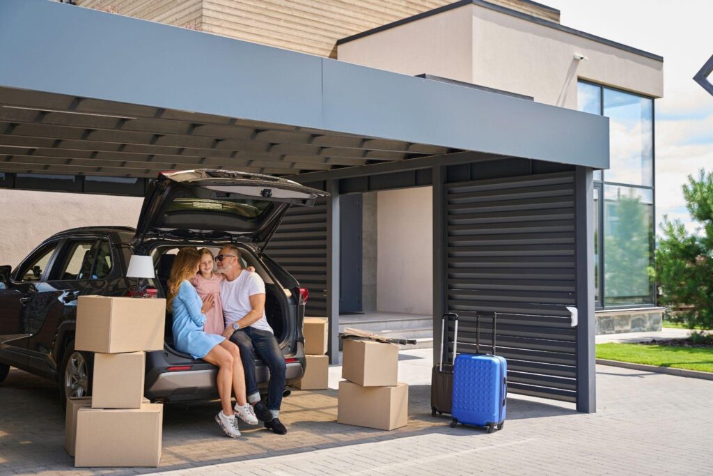 Family at SUV under a modern driveway carport—residential shade installation providing vehicle and driveway protection at a contemporary home.