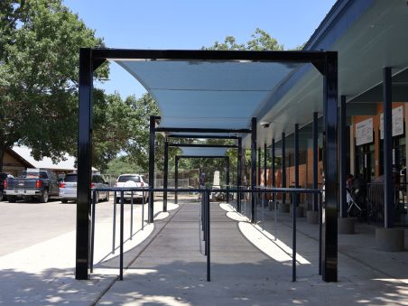 Modern outdoor shade structure installed over a curved pool