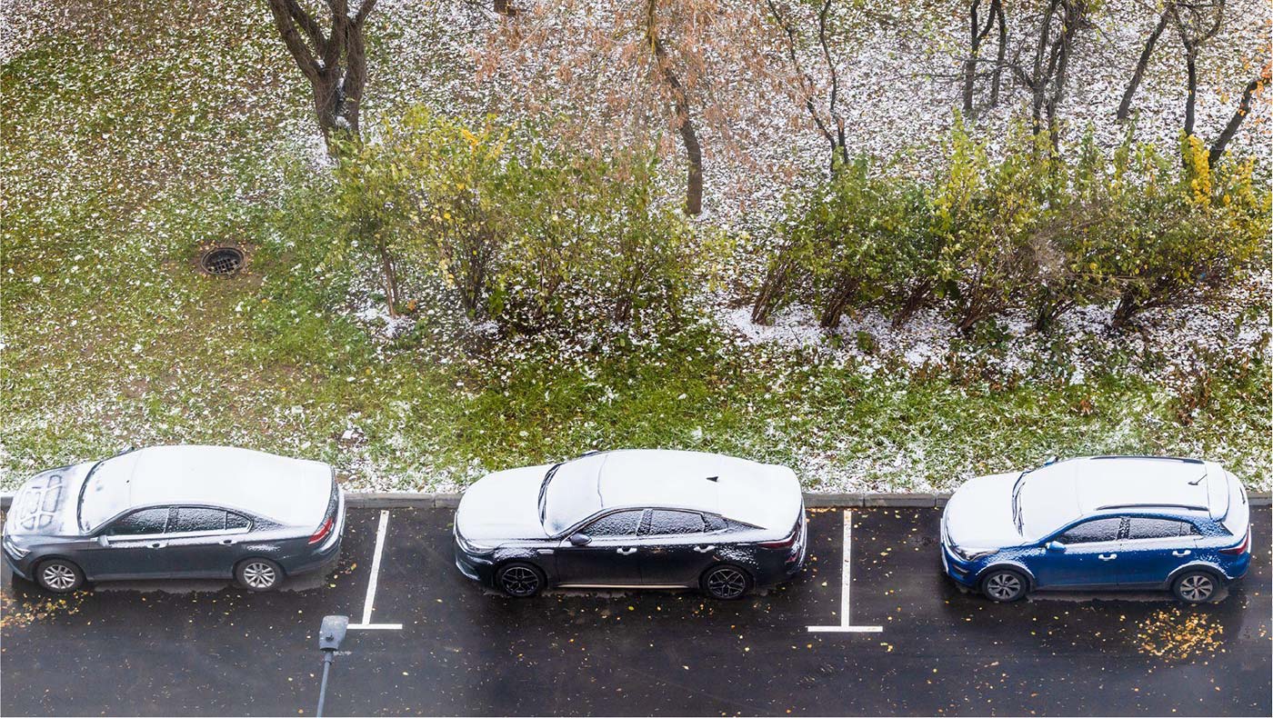hailstones on an unprotected dealership lot showing hail damage risk to vehicle inventory