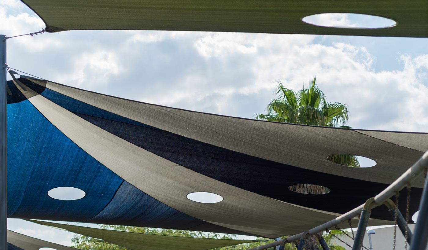 shade sail canopy over playground equipment protecting play areas from sun
