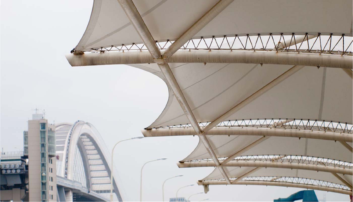 tensioned fabric canopy providing hail protection for cars across a Texas dealership lot